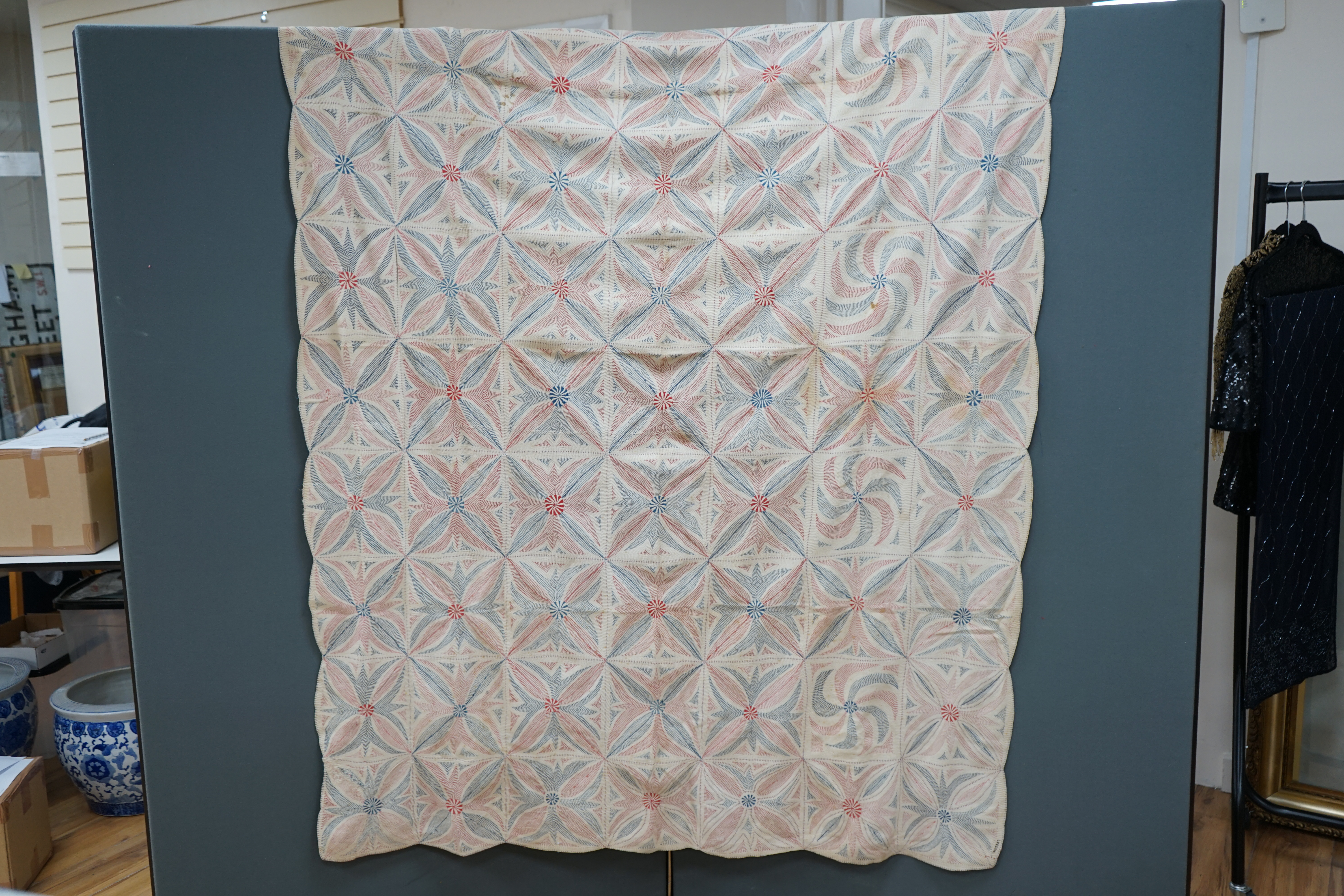 An early 20th century West Bengal Kantha embroidered quilt, embroidered on cream cloth (possibly made from layers of old saris) embroidered in blue and red threads, designed in squares of large abstracted floral motifs u